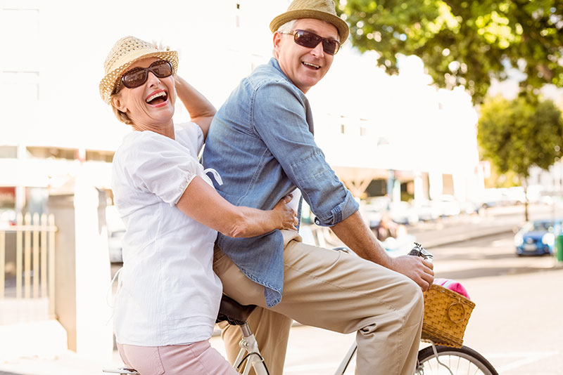 man and woman on bicycle with hearing aids
